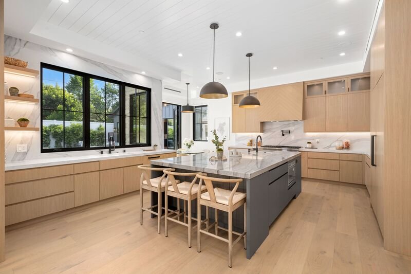 Cocina moderna y amplia dentro de una casa con vista al jardín